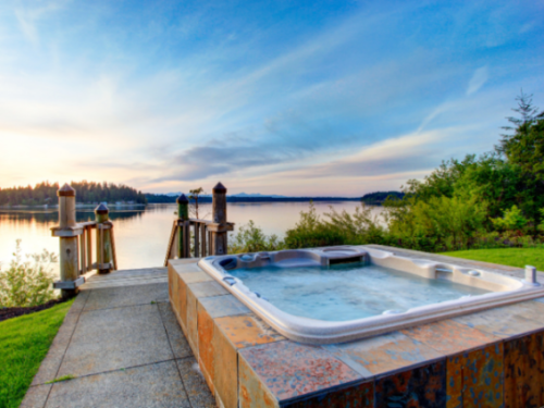 Outdoor hot tub with view over lake and mountains