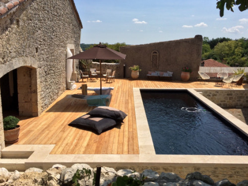 Stunning rectangular swimming pool with wood deck and stone accents