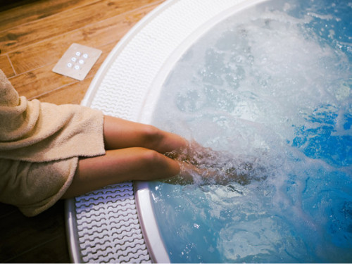wellnessvrouw ontspannen met voeten in massagebad